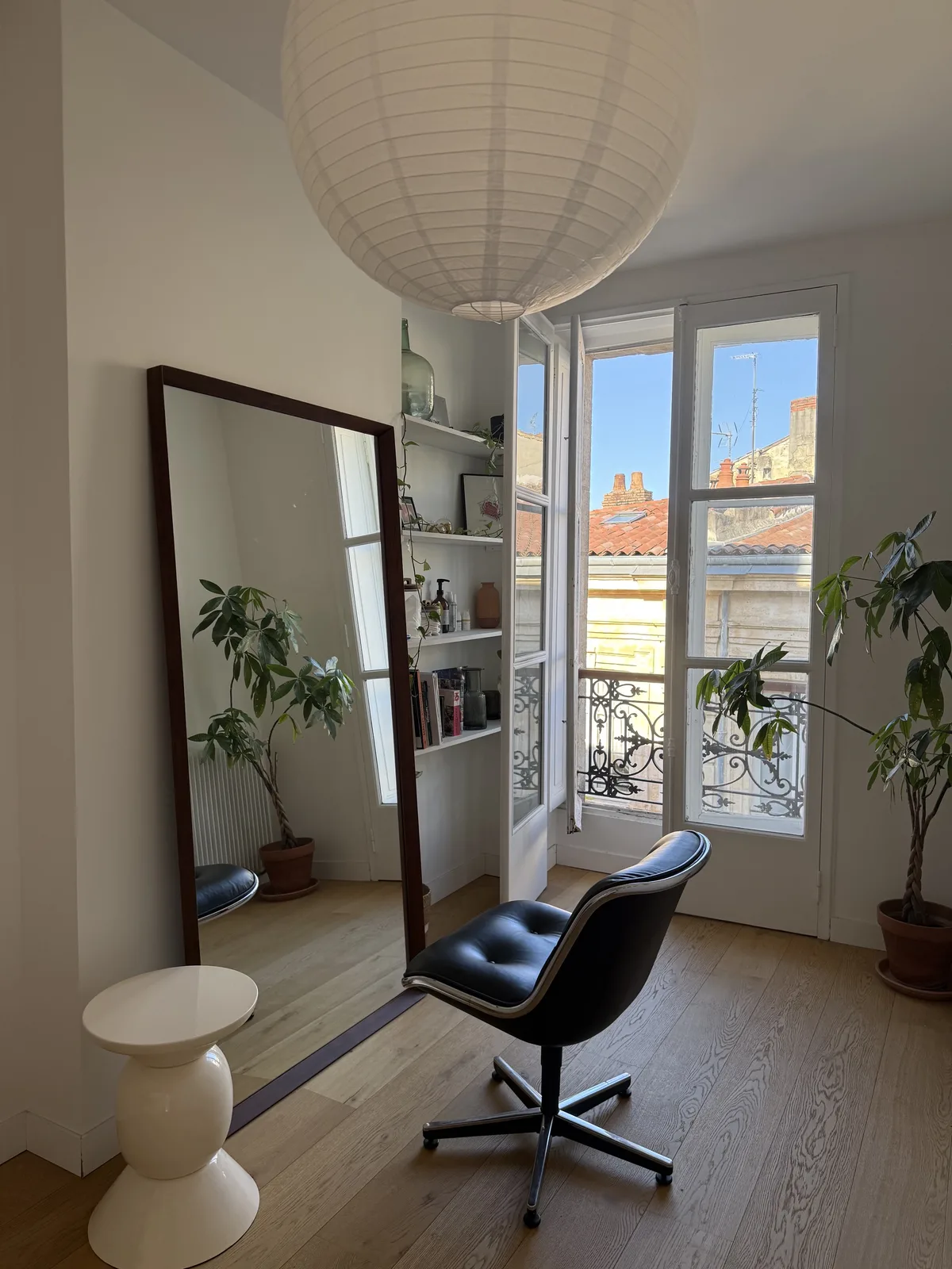 Le studio d'Anne-Sophie Roux à Bordeaux : miroir, fauteuil et fenêtre donnant sur les toits